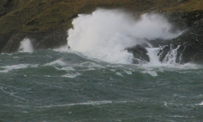 Waves crash against rocks during stormy weather